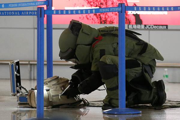 A bomb disposal expert checks a luggage near the site of a blast at a terminal in Shanghai’s Pudong International Airport