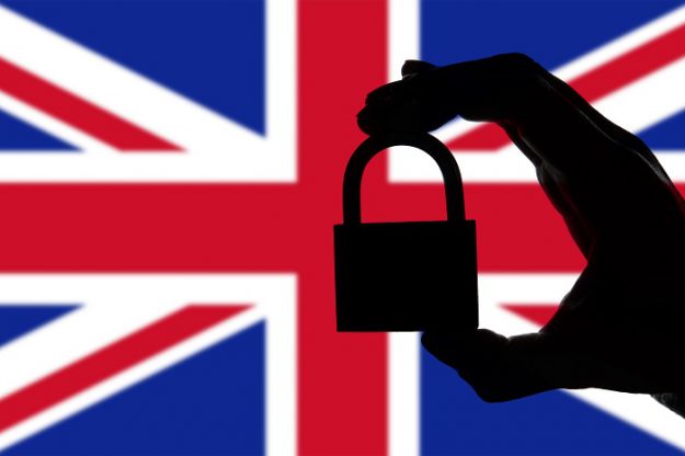 United Kingdom security. Silhouette of hand holding a padlock ov